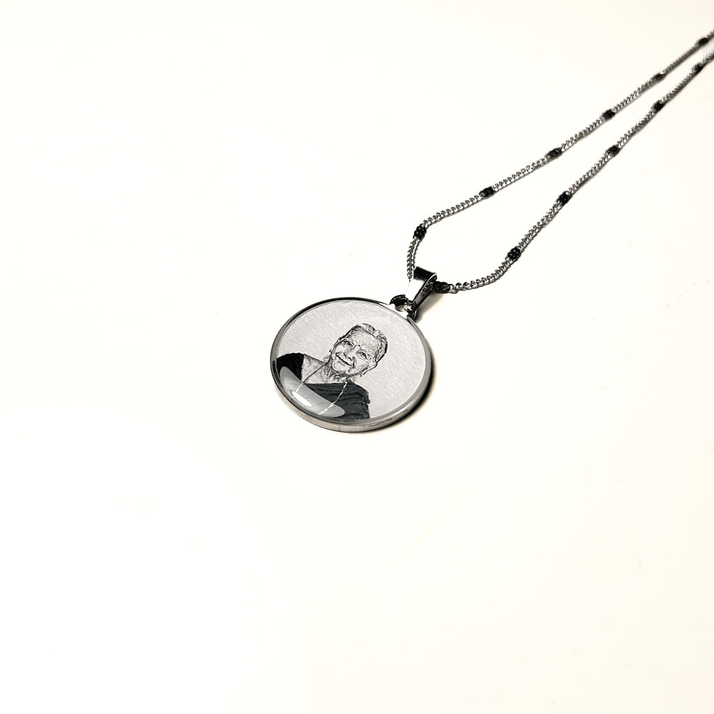 Necklace with a pendant featuring a engraved portrait on a white background