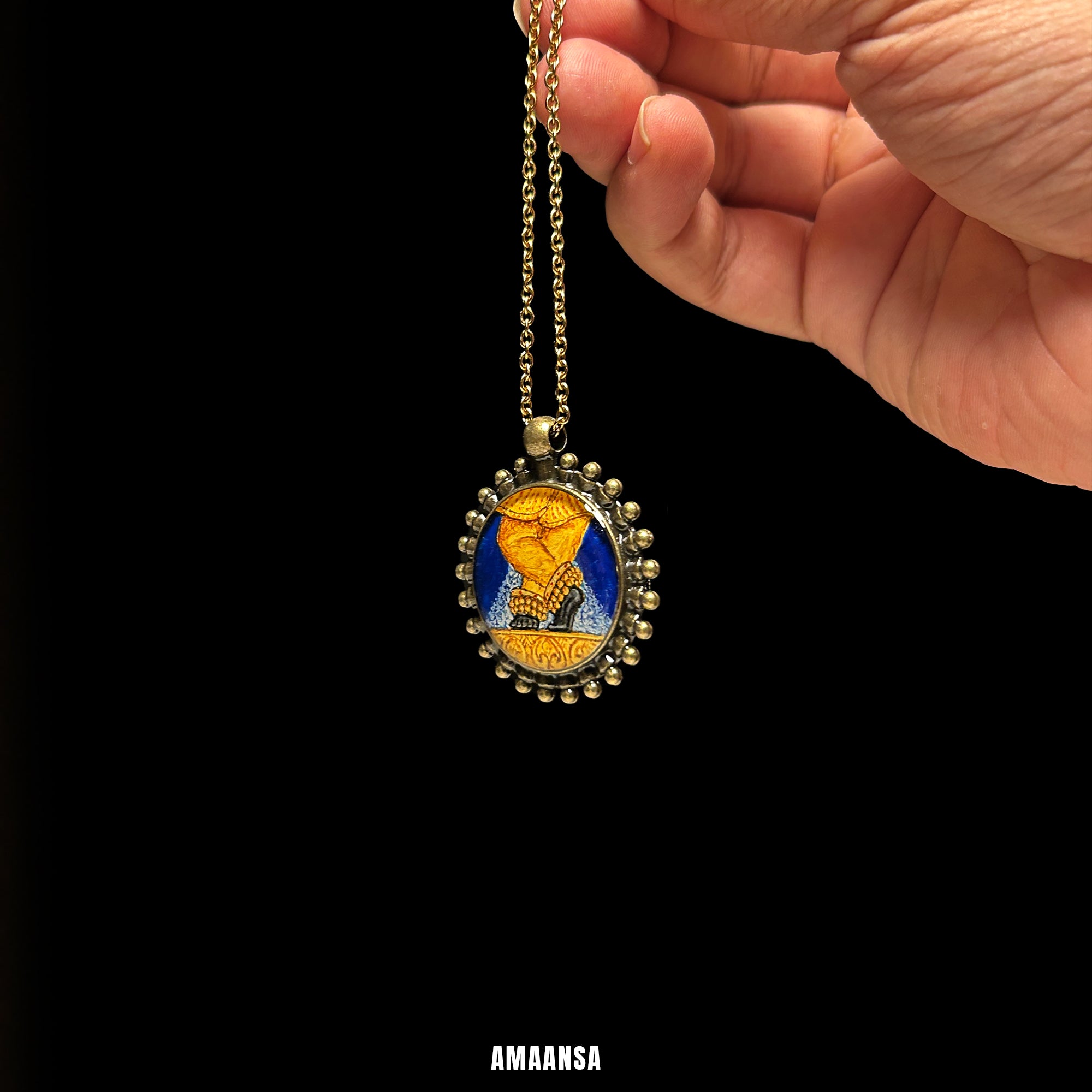 Hand holding a vintage necklace with a pendant  on a black background. Vintage-style locket handpainted Shri Shreenathji full color miniature painting devotional pendant antique patina chain spiritual jewelry religious coin divine blessing collector art