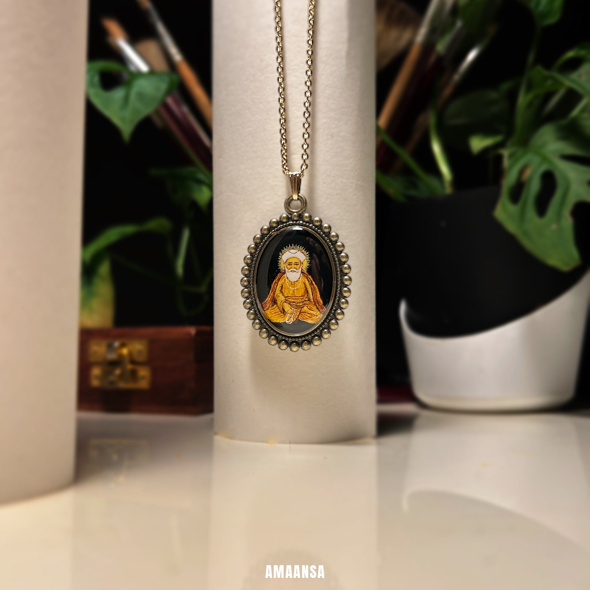 Necklace with pendant featuring a portrait on a white cylindrical object with plants in the background. Custom deity locket handpainted Guru Nanak vintage pendant spiritual jewelry Hindu Sikh god coin religious necklace divine blessing devotional chain meditative sitting pose any deity made to order AMAANSA spiritual artistry