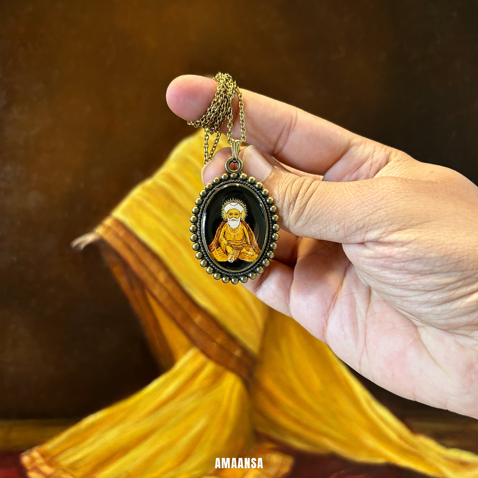 Hand holding a necklace with a pendant featuring Gurunanak painting against a blurred background. Handpainted spiritual locket custom deity pendant Guru Nanak vintage jewelry religious coin divine protection any god pendant made to order Sikh spiritual necklace devotional keepsake meditative guru artistry AMAANSA
