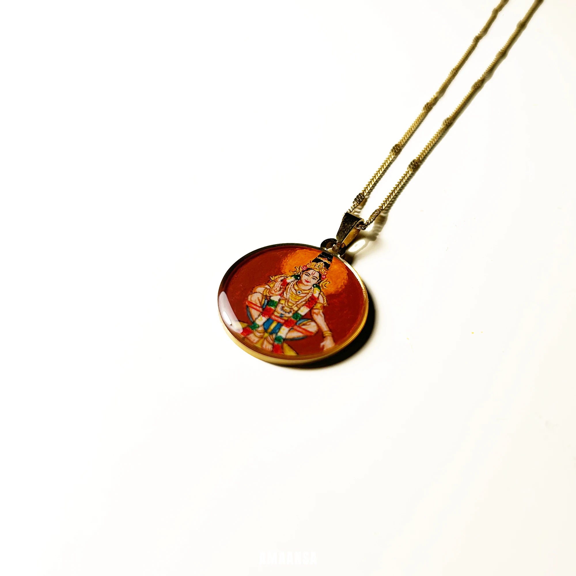 Close‑up of Lord Ayyappa pendant dark red-maroon showing crown and ornaments, devotional necklace detail shot featuring an miniature painting of a deity on a white reflective background