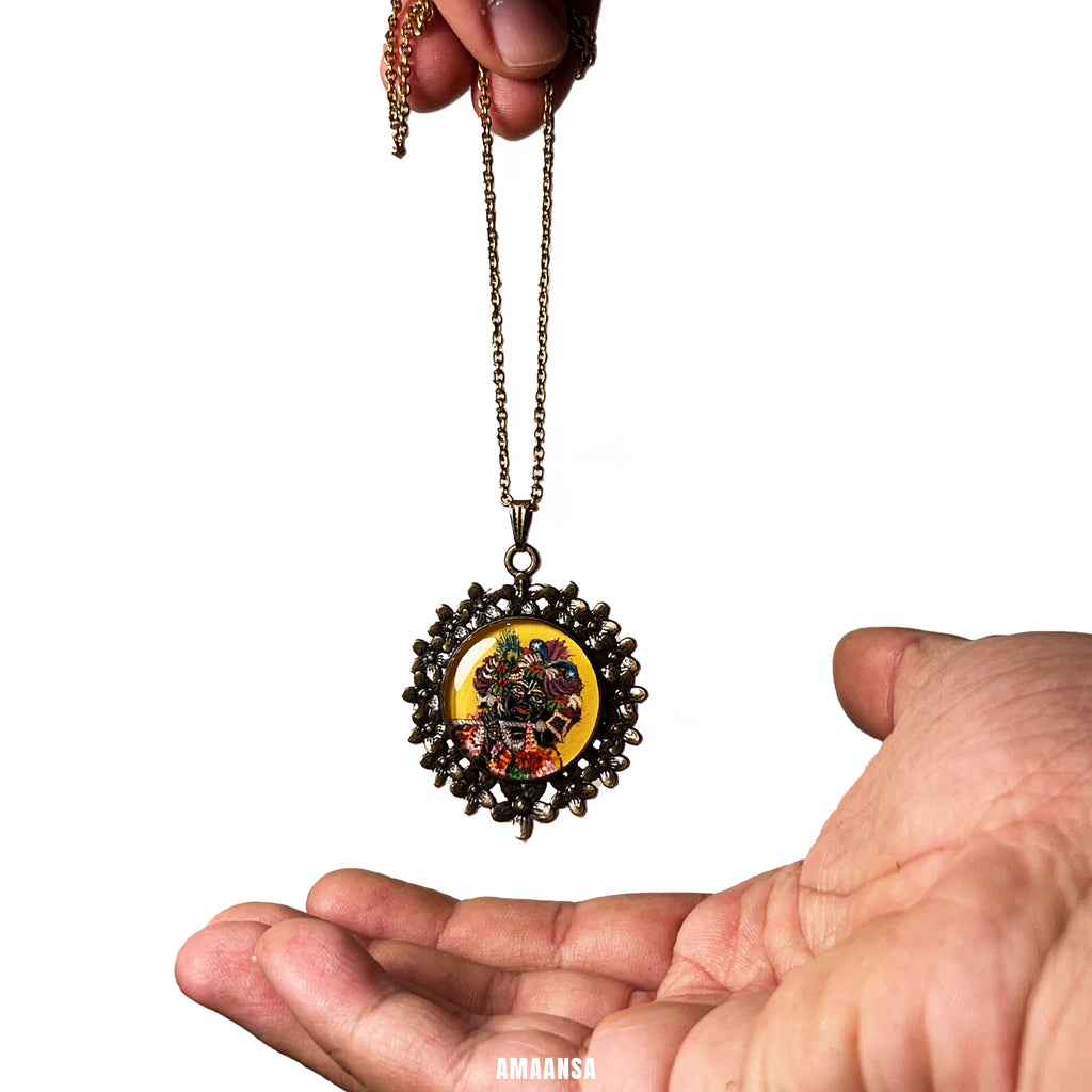 Hand holding a Banke Bihari pendant necklace against a white background, Vrindavan‑inspired devotional jewelry