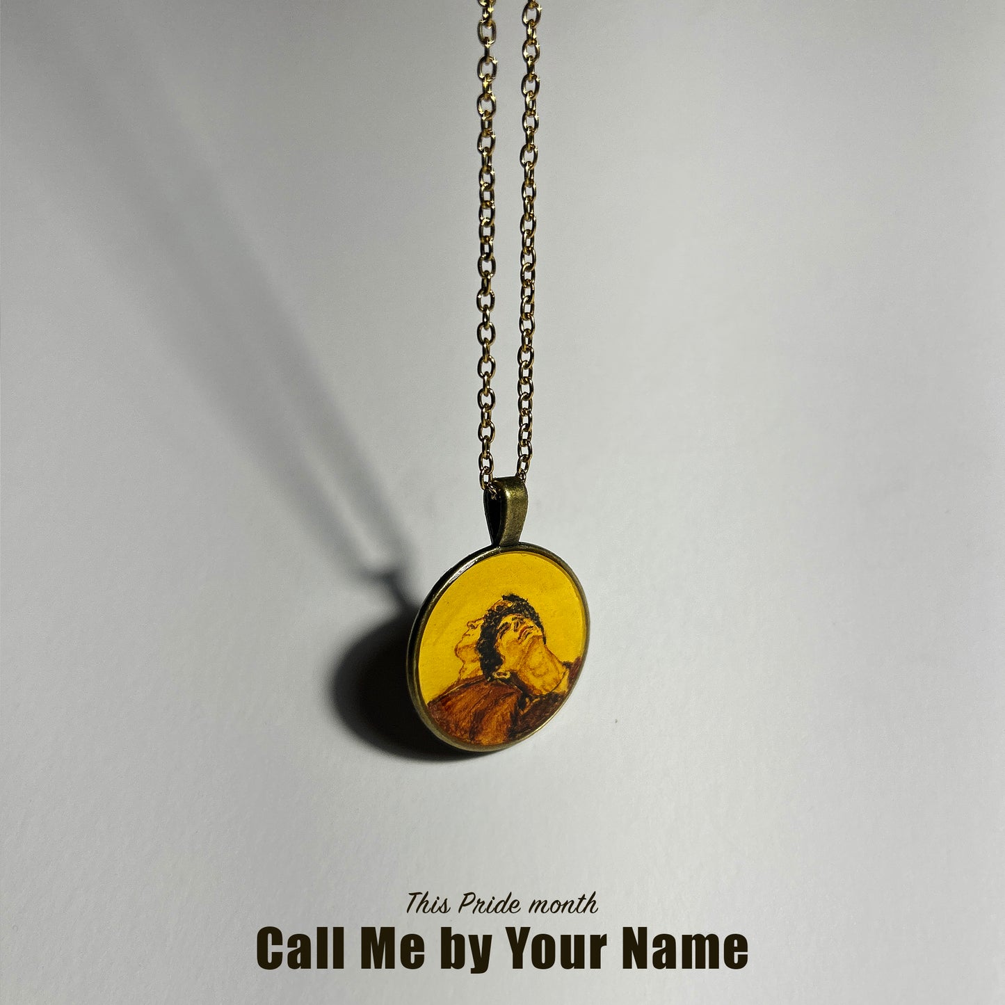 A handcrafted pendant from AMAANSA Fine Arts Studio’s Pride Collection, featuring a detailed miniature painting of the movie cover 'Call Me by Your Name.' The vibrant portrait is painted on a circular pendant, representing the themes of love and identity. The pendant is showcased as a tribute to the LGBTQ+ community.