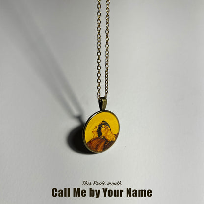 A handcrafted pendant from AMAANSA Fine Arts Studio’s Pride Collection, featuring a detailed miniature painting of the movie cover 'Call Me by Your Name.' The vibrant portrait is painted on a circular pendant, representing the themes of love and identity. The pendant is showcased as a tribute to the LGBTQ+ community.