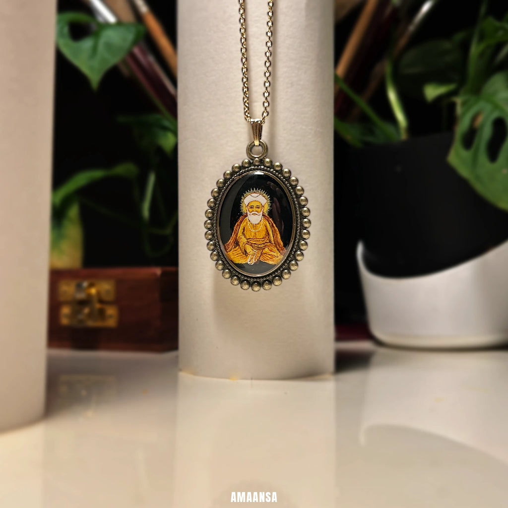 Guru Nanak miniature portrait pendant on soft beige background, calm expression highlighted, seated figure on a white cylindrical object, with plants in the background.