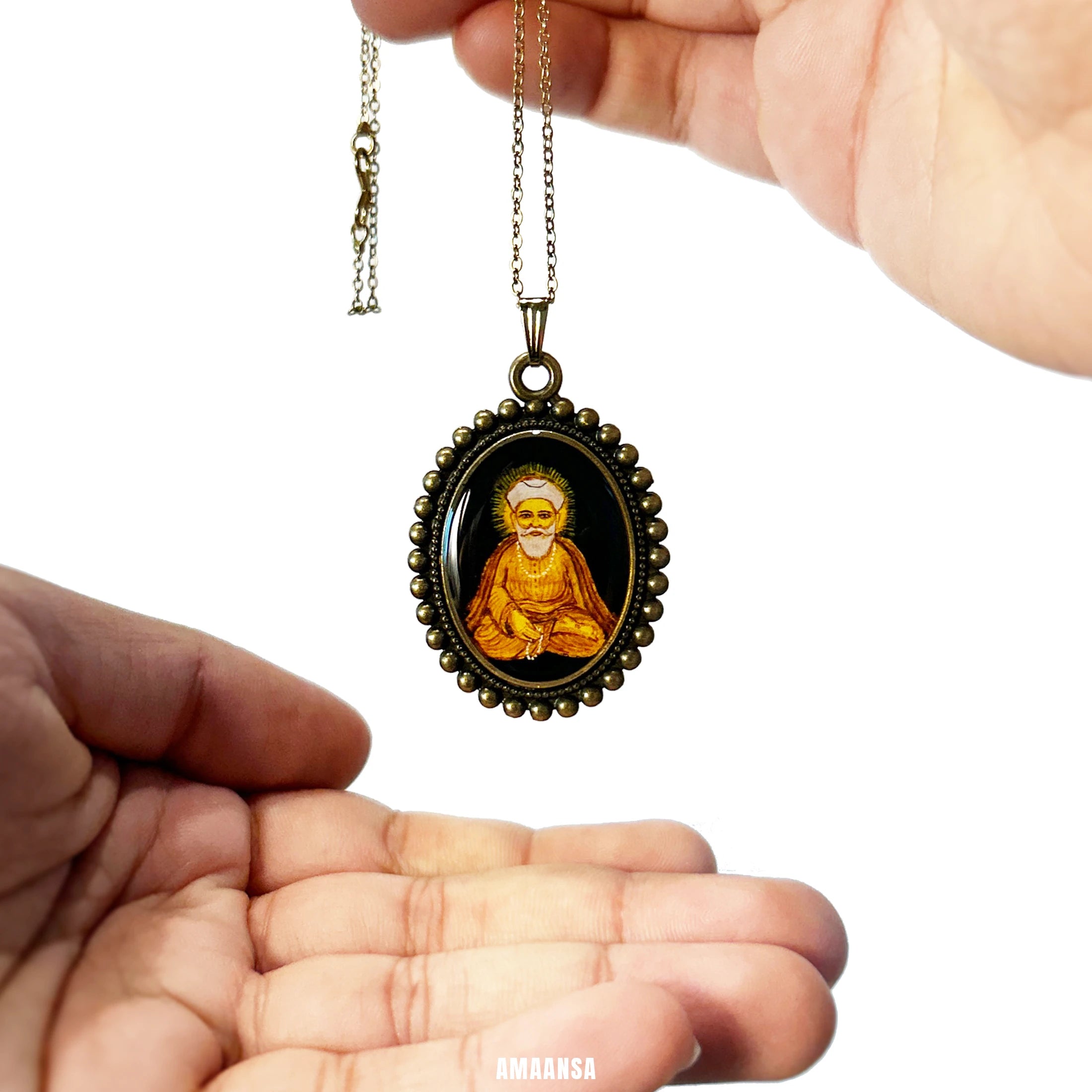 Close‑up of Guru Nanak pendant showing turban and gentle gaze, spiritual art necklace on a white background