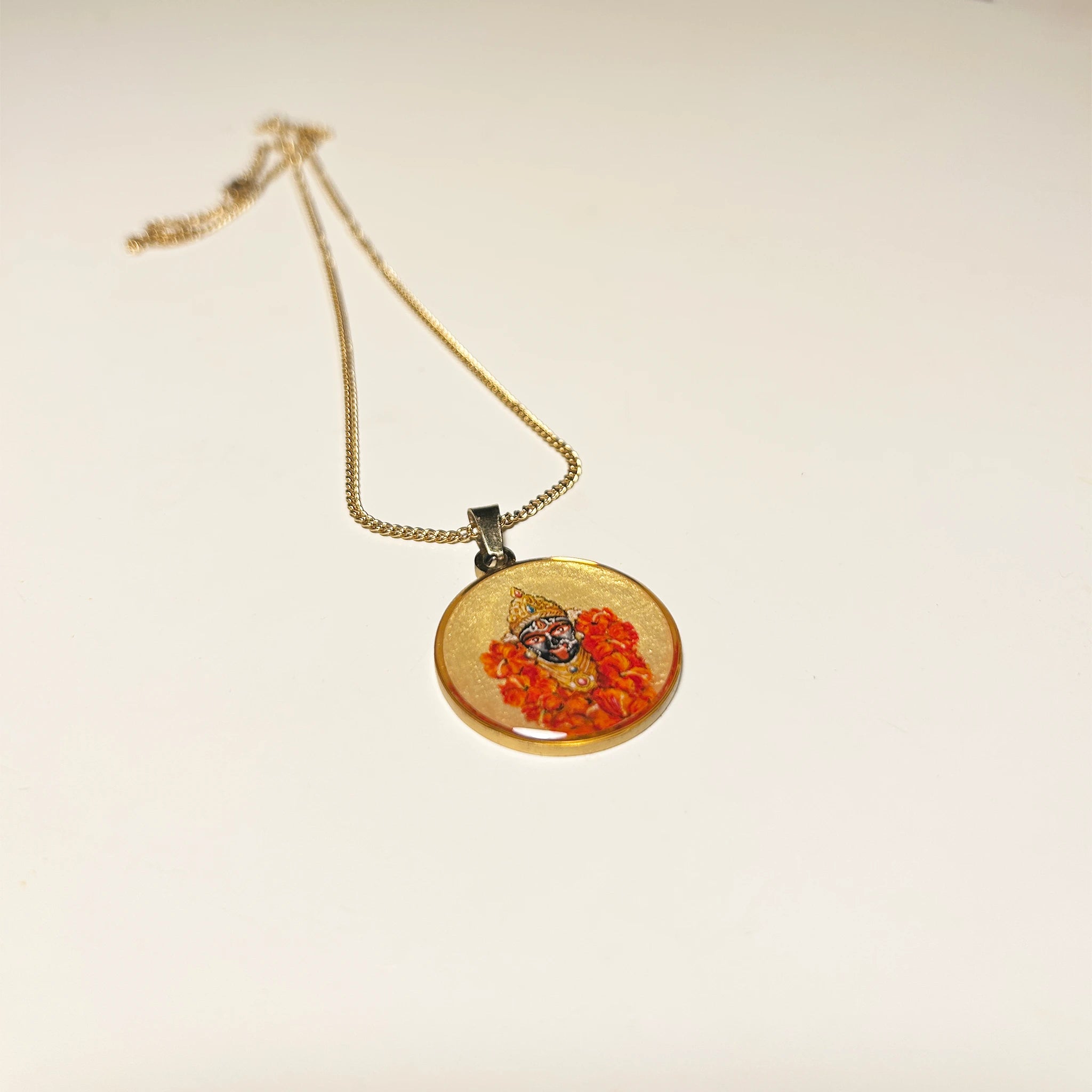 Side‑angled view of 18k gold‑plated Maa Kali hand‑painted miniature pendant on chain, devotional necklace against clean studio backdrop.