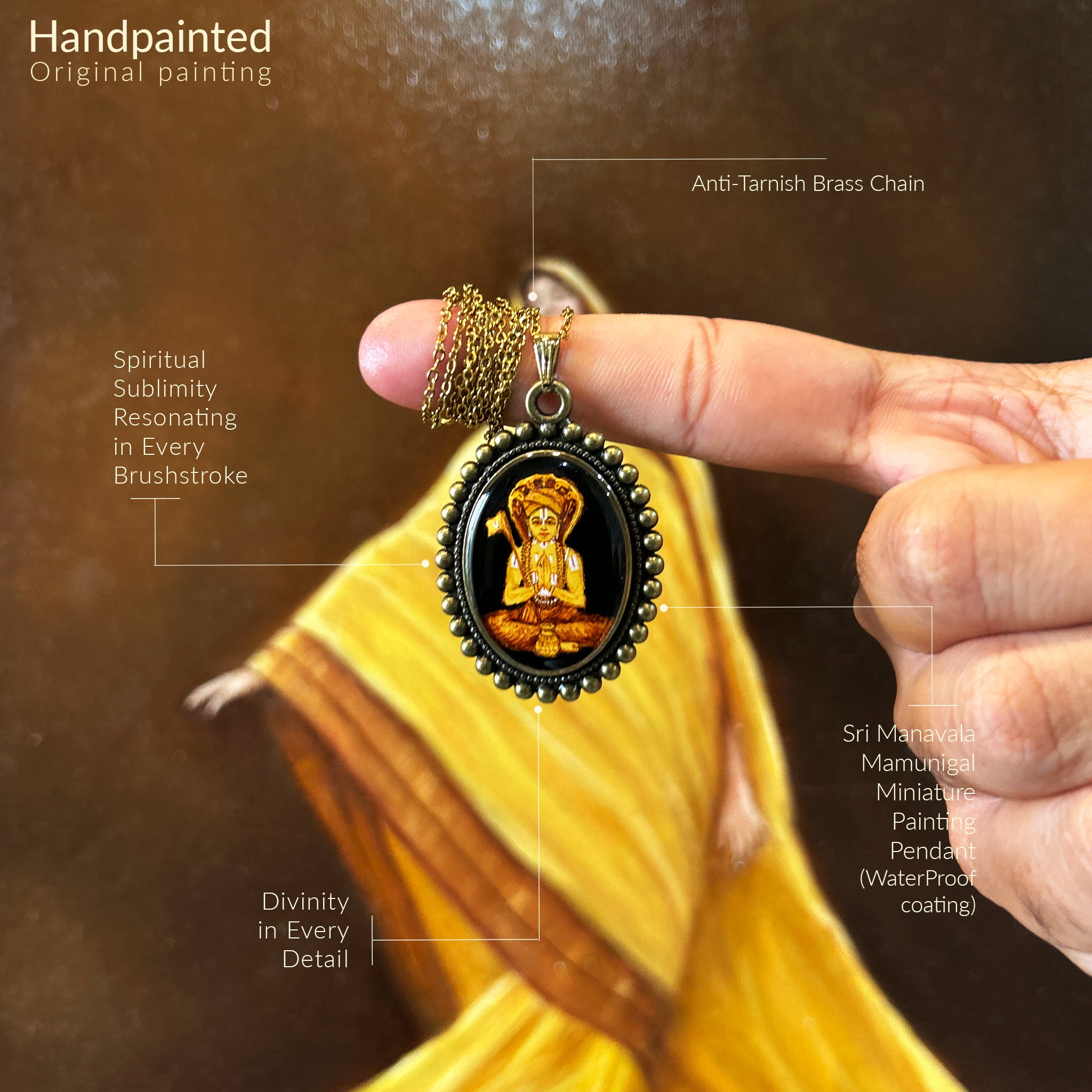 "AMAANSA's sacred oval pendant (31x23mm) featuring Sri Manavala Mamunigal's complete portrait with intricate details. His distinctive crown adorned with six sacred serpents, right hand holding the divine flag symbolizing spiritual victory. Vintage Pearl Border in antique brass finish frames this devotional artwork. Chain elegantly wrapped around finger with pendant suspended against flowing yellow backdrop. Protected by crystal-clear sealant, this blessed keepsake preserves traditional iconography