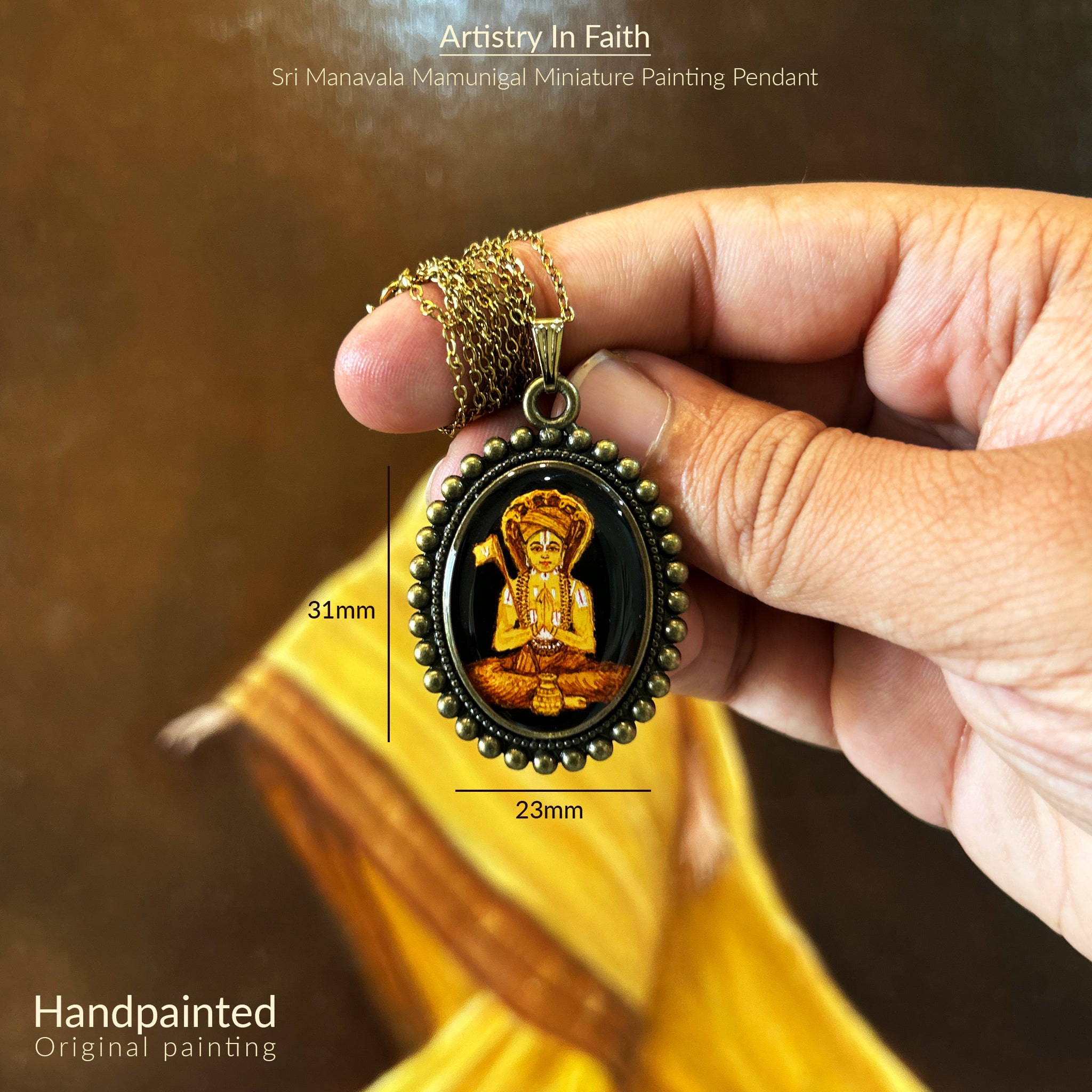 AMAANSA Fine Arts Studio presents: Devotional oval pendant (31x23mm) featuring Sri Manavala Mamunigal's complete portrait. His serene meditation posture and traditional attire rendered in rich golden hues, embraced by our Vintage Pearl Border design. Antique gold colored chain gracefully suspended, pendant held between fingers against warm backdrop. Sealed with protective finish, this sacred art piece honors spiritual legacy.