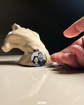 Hand holding a necklace with a pendant featuring a couple's photo, placed on a textured surface.