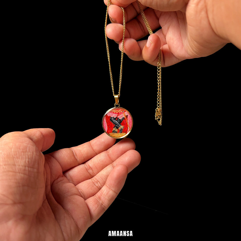 Round 18k gold‑plated Sri Radharamanji paduka pendant on chain, devotional necklace centred and held by hands against a black background.