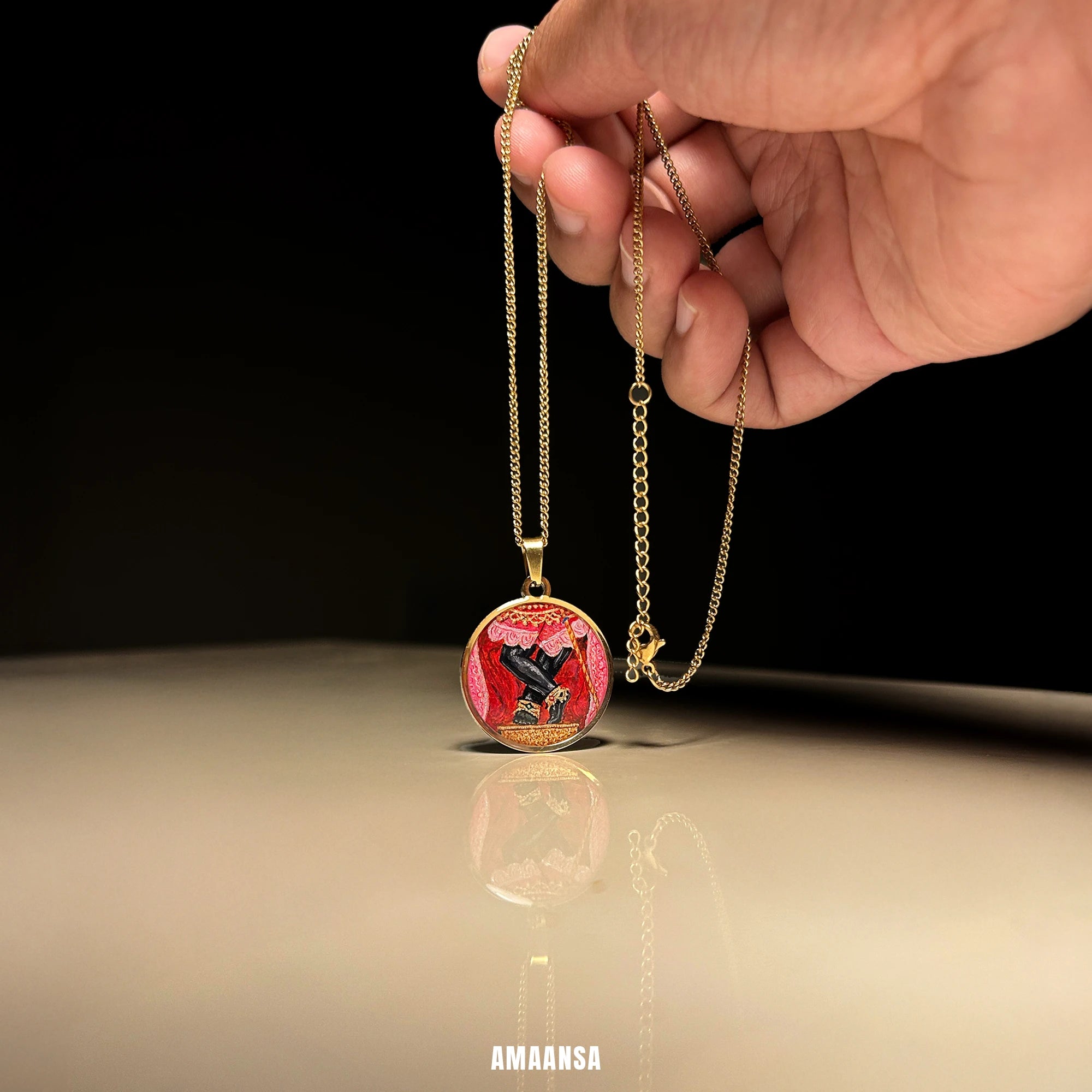 Close‑up of 18k gold‑plated Sri Radharamanji paduka miniature pendant, detailed red shrine background emphasising sacred feet artwork.