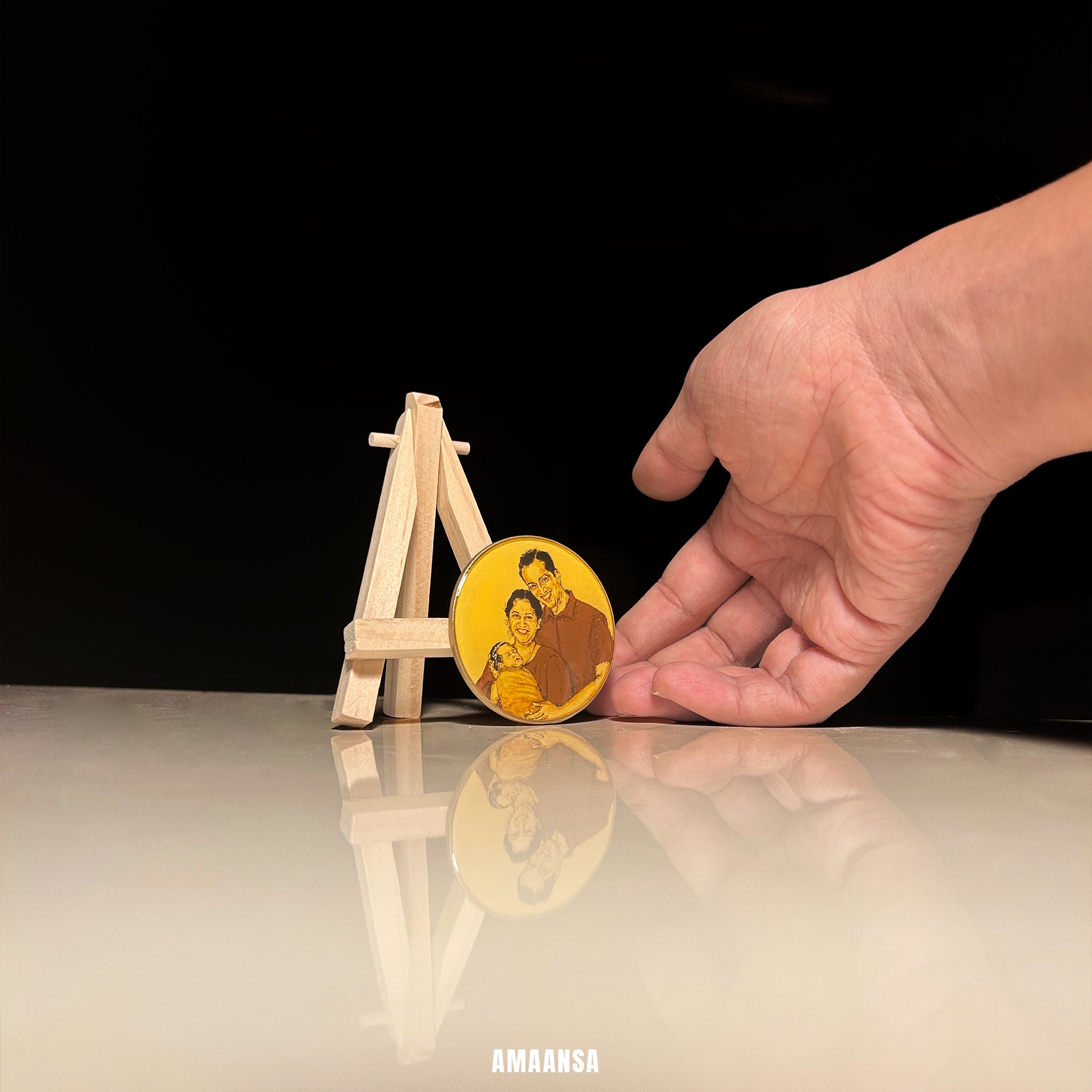 Hand holding a gold coin with a family portrait on a reflective surface with a black background, Custom three figure tabletop miniature portrait new family couple newborn baby handpainted keepsake wooden easel stand desk display husband commissioned family legacy vintage style collectible art treasure