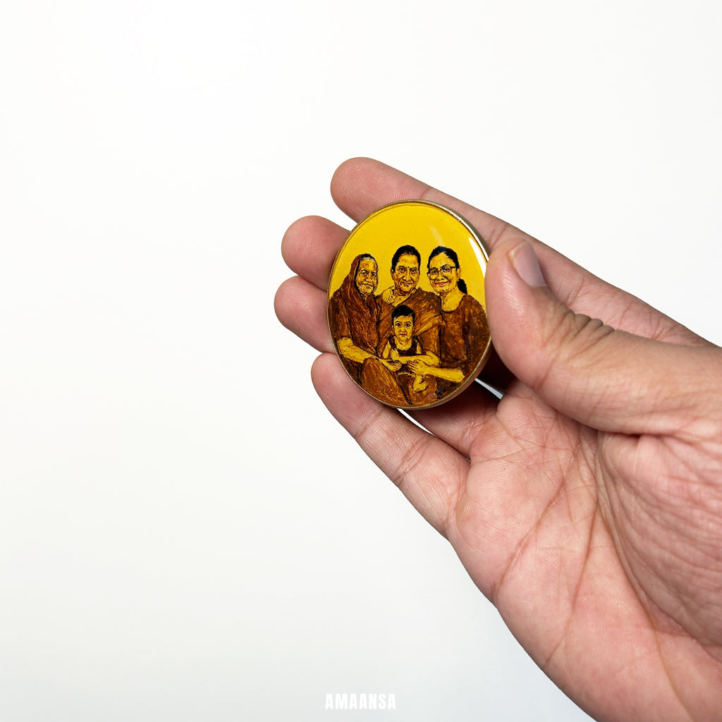 Hand holding a round yellow object with a family portrait on a white  background. Custom four figure tabletop miniature portrait three generations women family grandmother mother wife newborn handpainted keepsake wooden easel stand husband commissioned generational legacy vintage style AMAANSA collectible