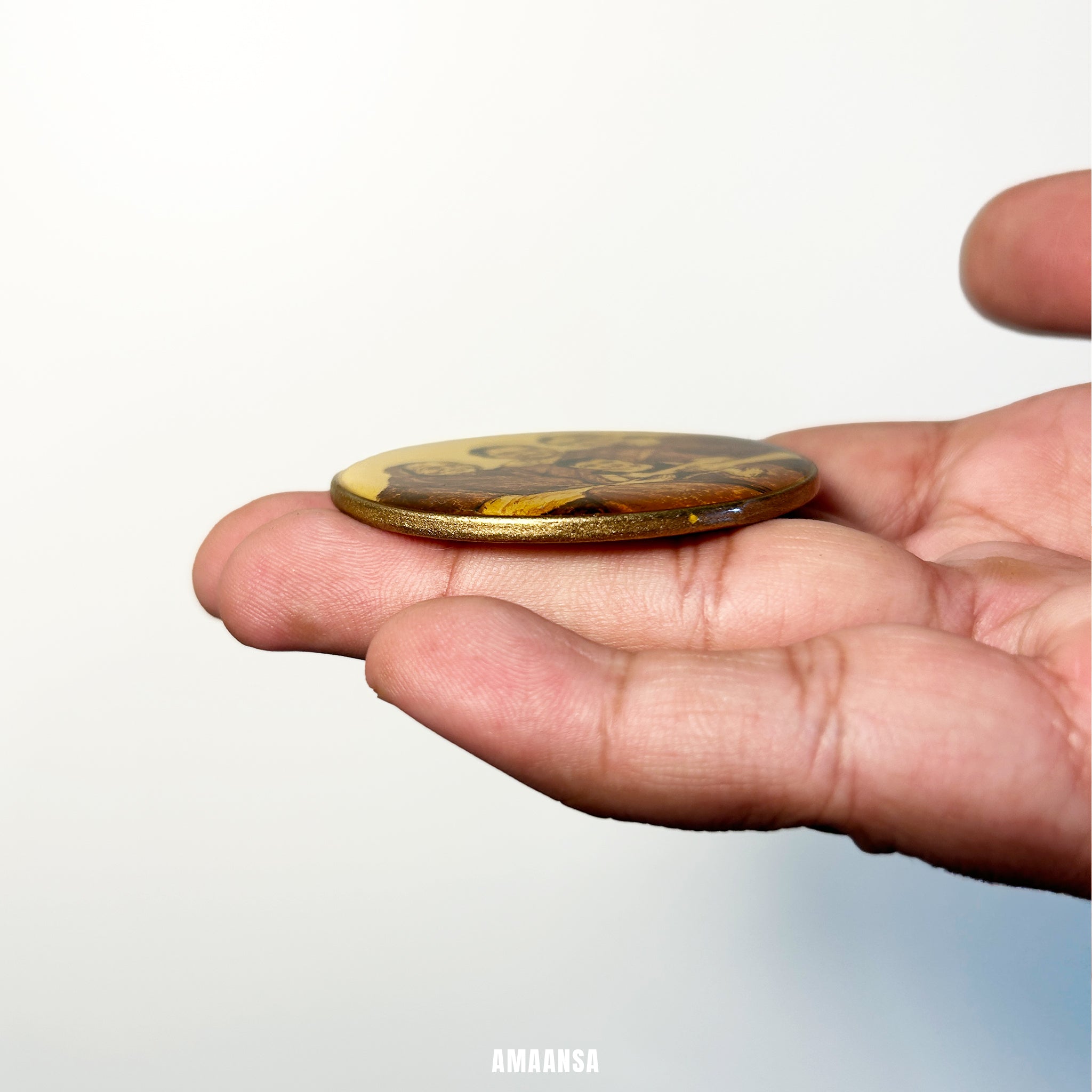 Hand holding a small gold coin with intricate designs against a white background. Handpainted miniature portrait four figure family tabletop display three generations women newborn child wooden stand desk accessory husband commissioned family heritage vintage style collectible generational treasure