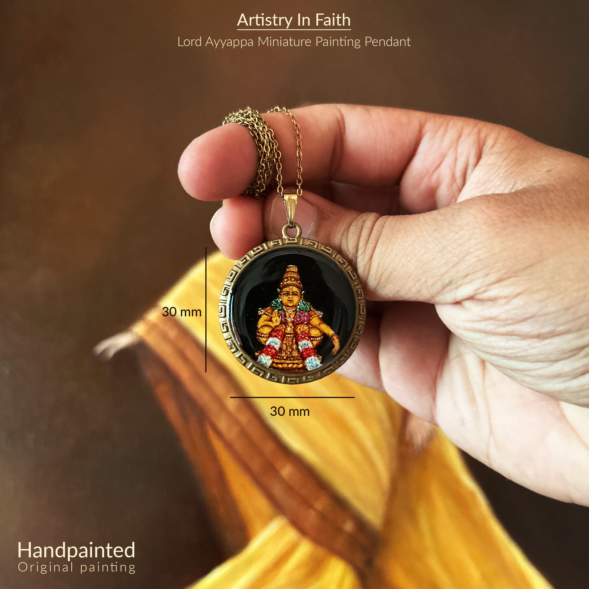 Artistry in Faith Collection - Detailed 30mm Lord Ayyappa pendant held between thumb and index finger against warm-toned background, showing precise measurement guides. Hand-painted deity on mystical black background framed by vintage-styled Greek key border, showcasing intricate ceremonial attire in rich golds and reds with sacred garlands. Delicate antique brass chain draped across fingers, emphasizing both scale and devotional artistry of this wearable spiritual keepsake