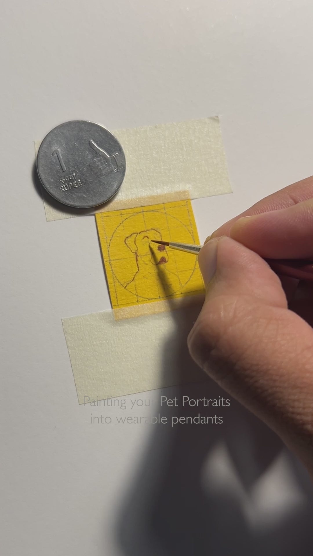 20-second artisan journey: from miniature painting to finished pendant, showcasing attentive dog portrait creation smaller than one-rupee coin. Initial clip reveals meticulous brushwork detailing noble canine profile on naples yellow canvas, each feature smaller than artist's fingernail. Final sequence displays completed pendant with ornate black beaded frame against warm amber backdrop, pendant held in palm with delicate chain, enhanced with protective gloss finish.