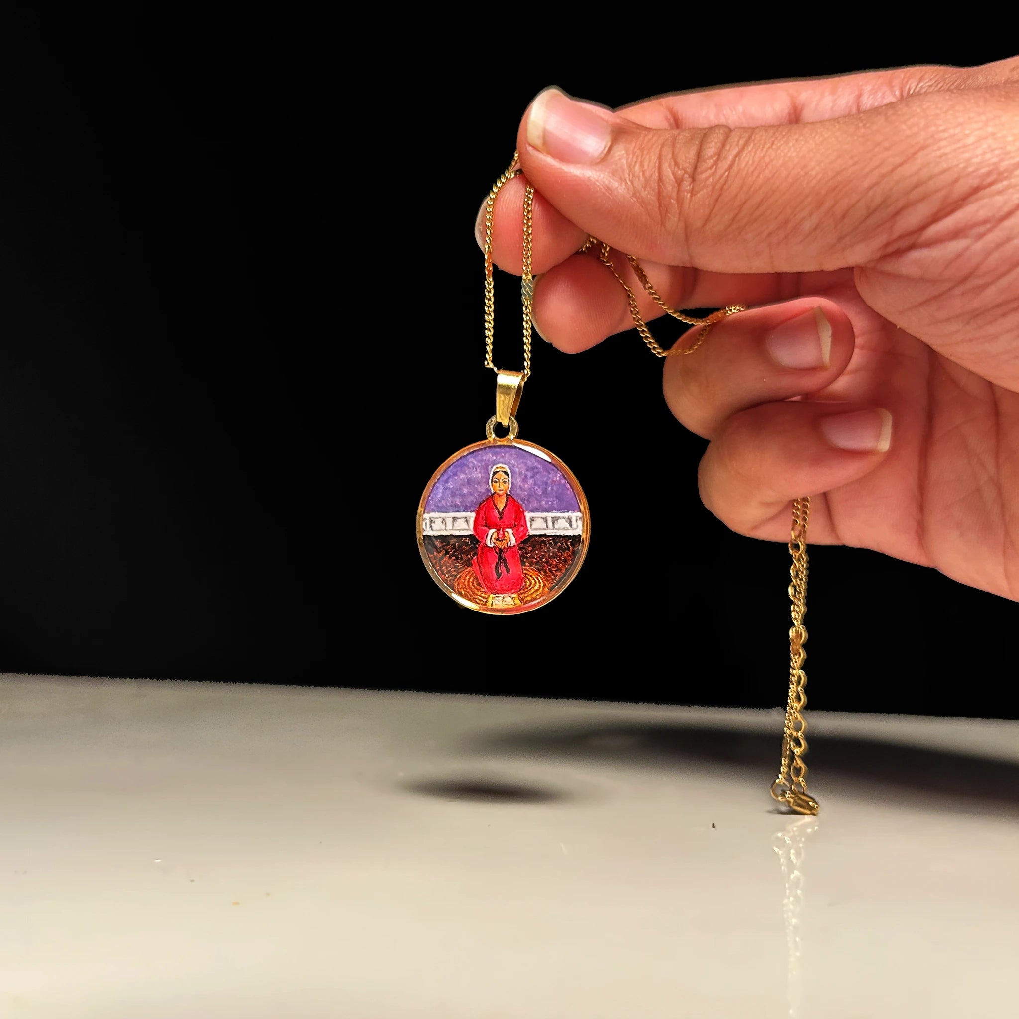 Mata Rupa Bhawani hand‑painted miniature pendant on 18k gold‑plated chain, devotional necklace suspended above open hands to suggest blessing.
