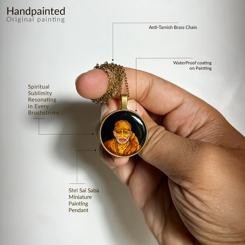 AMAANSA's sacred art pendant (26mm) featuring Shirdi Sai Baba's divine portrait, delicately held to demonstrate its intimate scale against fingertips. Each brushstroke radiates spiritual sublimity, protected by crystal-clear waterproof coating. Anti-tarnish brass chain elegantly wrapped around finger, pendant gracefully displayed against pure white backdrop. This blessed keepsake combines devotional artistry with durability, perfectly sized for everyday spiritual connection.