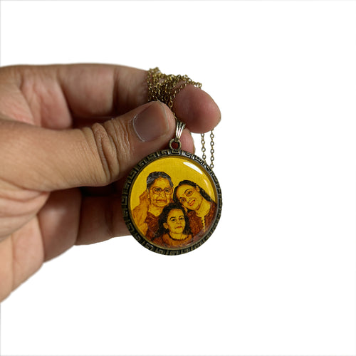 Meticulously rendered keepsake (32mm) capturing three generations: grandmother with glasses, radiant mother, and young child, each expression painted with care to preserve this moment. Held between thumb and fingers with antique gold colored chain cascading, the portrait painted in naples yellow to evoke vintage charm against crisp white backdrop. Greek key border frames this heritage piece, enhanced with luminous protective finish to create lasting family treasure.