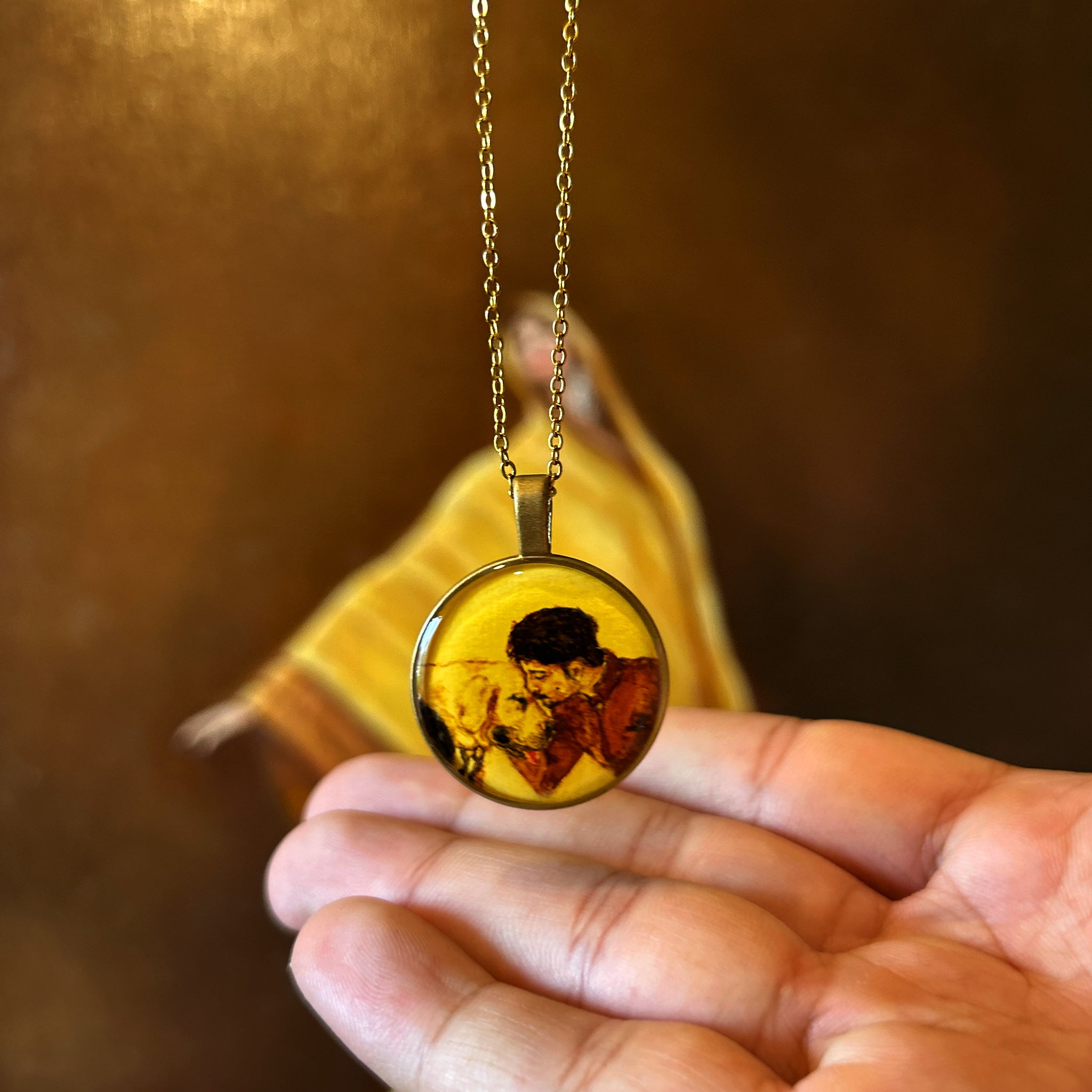 Meticulously crafted pet memorial pendant (2.6cm) showcasing tender connection: devoted owner kissing faithful dog's forehead, rendered in timeless sepia tones on naples yellow canvas. Heritage-inspired piece suspended from antique-finish chain, floating elegantly against artist's original oil painting backdrop - rich burnt umber and ochre hues illuminating traditional yellow sari, enhanced with crystal-clear sealant for lasting brilliance.