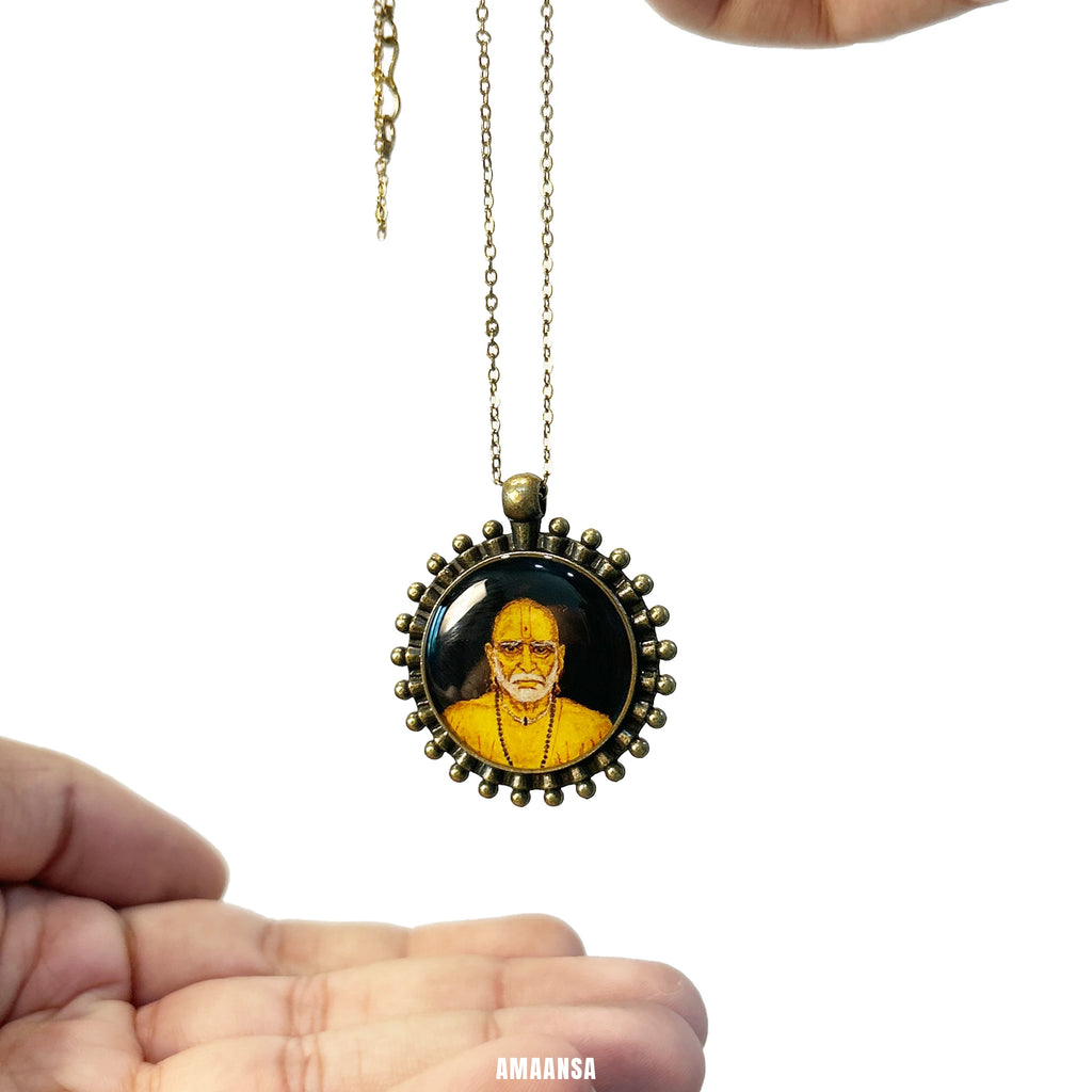 Swami Samarth hand‑painted miniature pendant on chain, devotional necklace against white background, in a vintage styled brass frame

